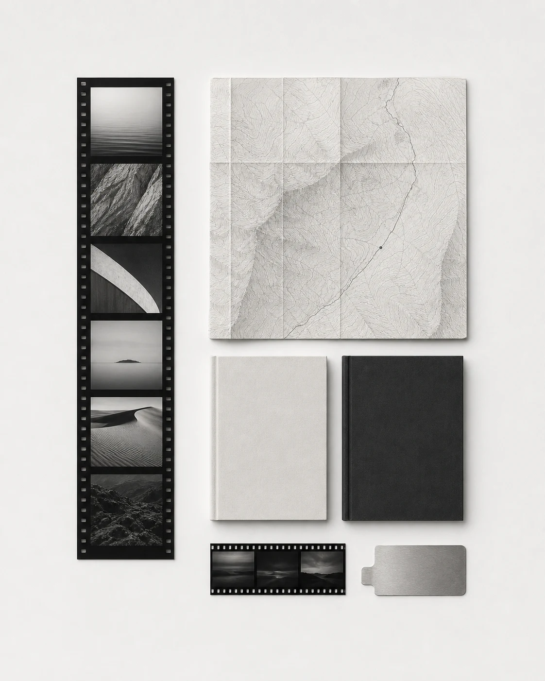 A monochrome personal archive of photographs, a topographic map, books, and film